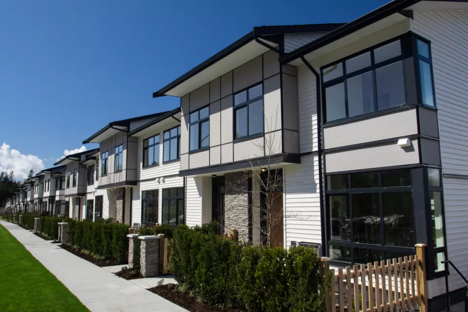 Row of white two-story townhomes with black trim